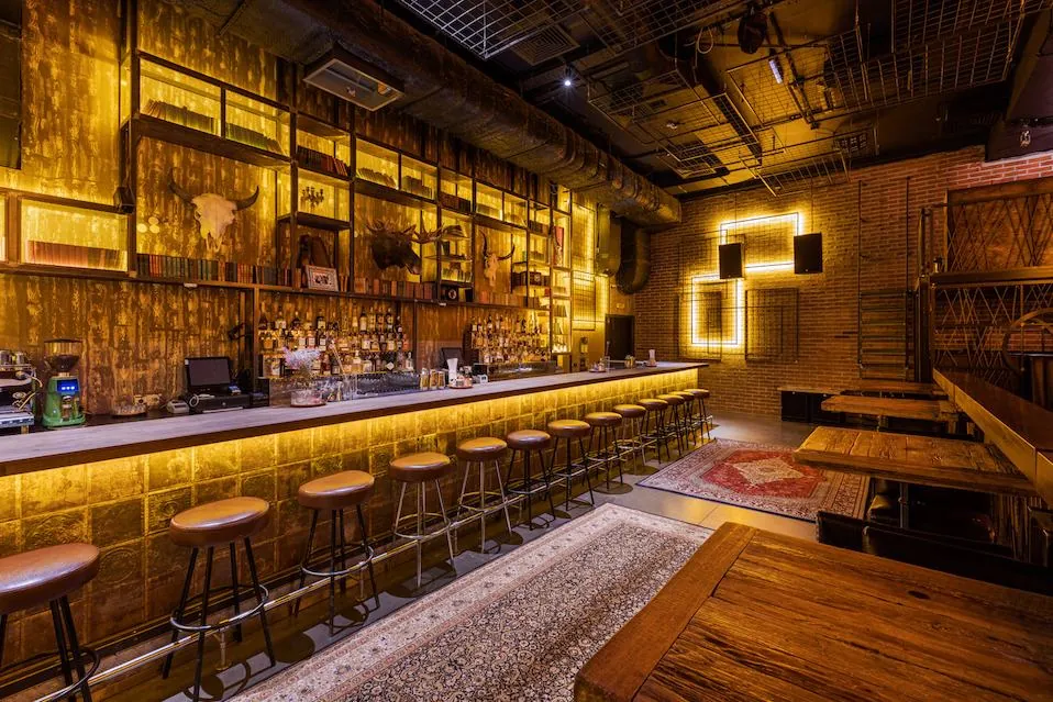 Cocktail bar with a backlit bar front and steel light frames