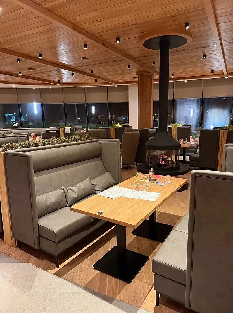 High-back booth sofas around a table on a steel base