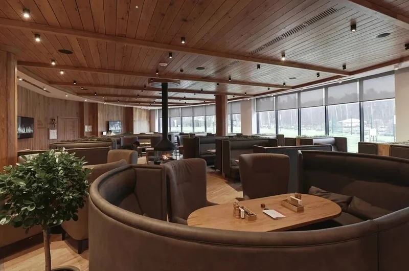 Restaurant hall with semicircular booths and a hanging fireplace