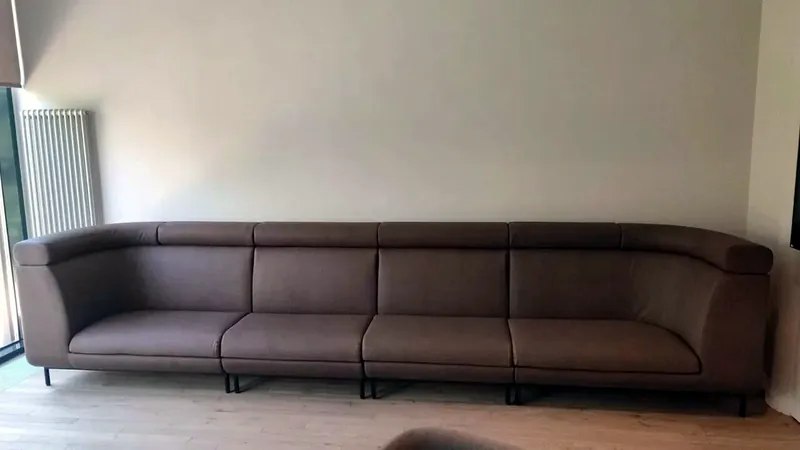 Long brown sofa made to the length of the wall
