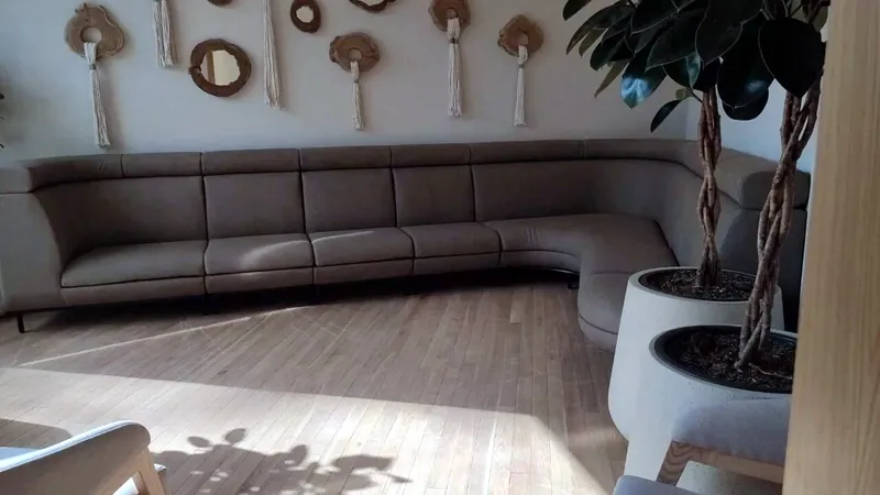 Long sofa curving along a wall under woven wall hangings