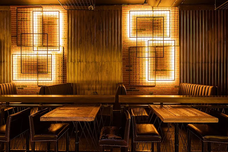 Row of leather booths under illuminated metal frames