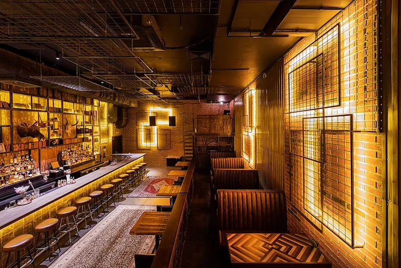 View along the bar with booths and metal light frames