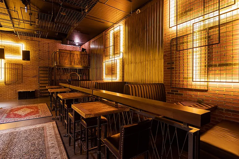 Bar room with metal grid panels and a leather bench