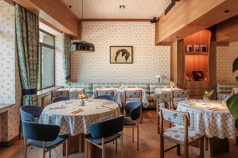 Restaurant hall with round tables, check upholstery and timber joinery