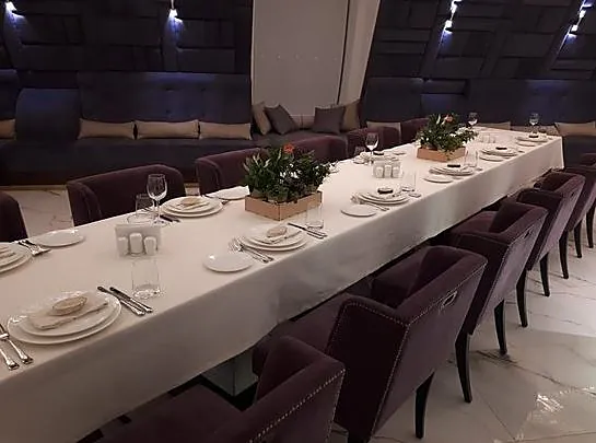Banquet table with purple upholstered chairs
