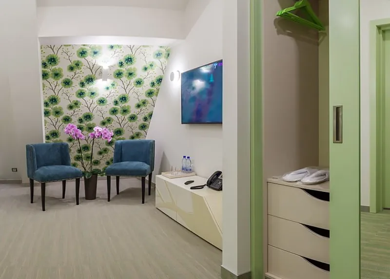 Room corner with two teal armchairs and orchids