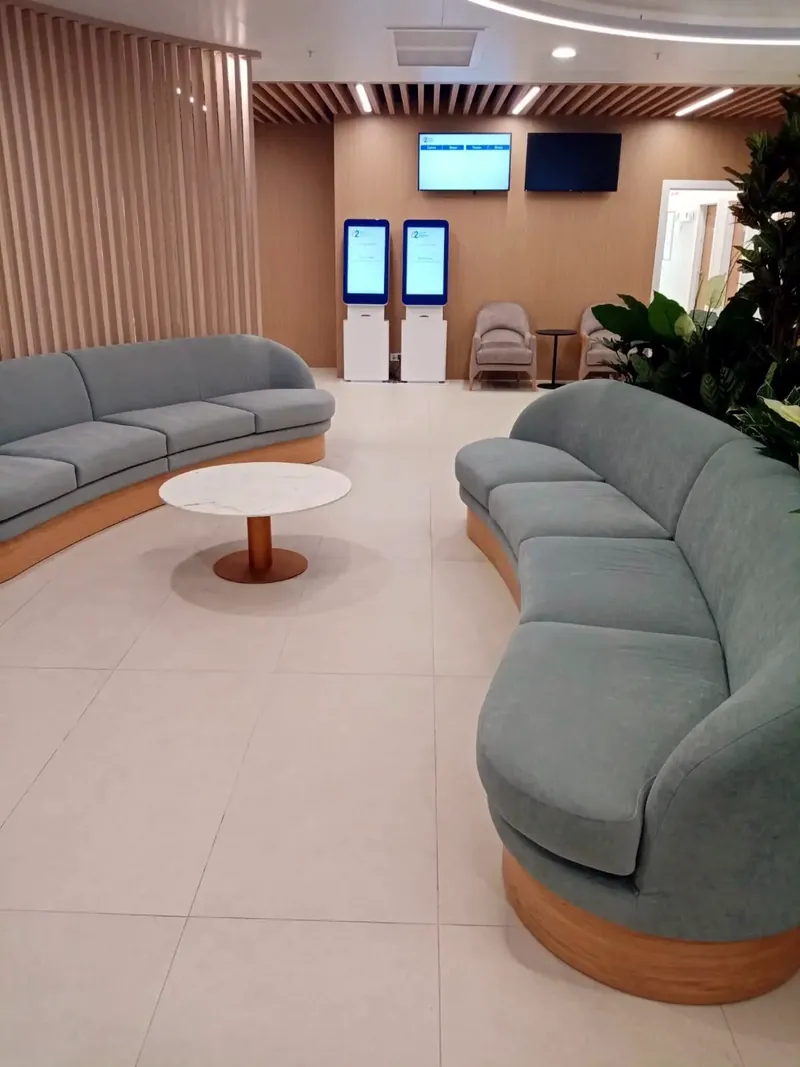 Pair of curved sofas on timber plinths in a waiting area