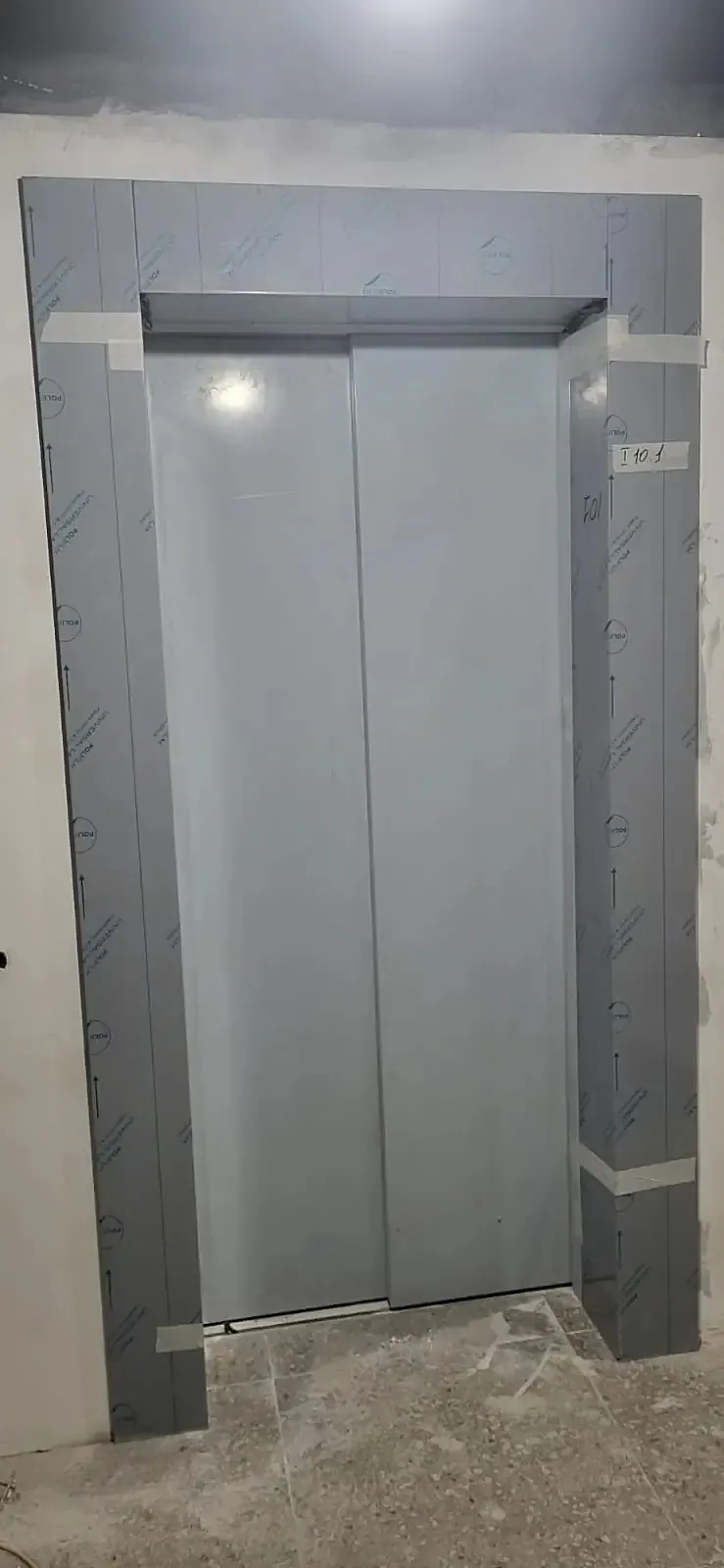 Steel surround around lift doors in a residential lobby