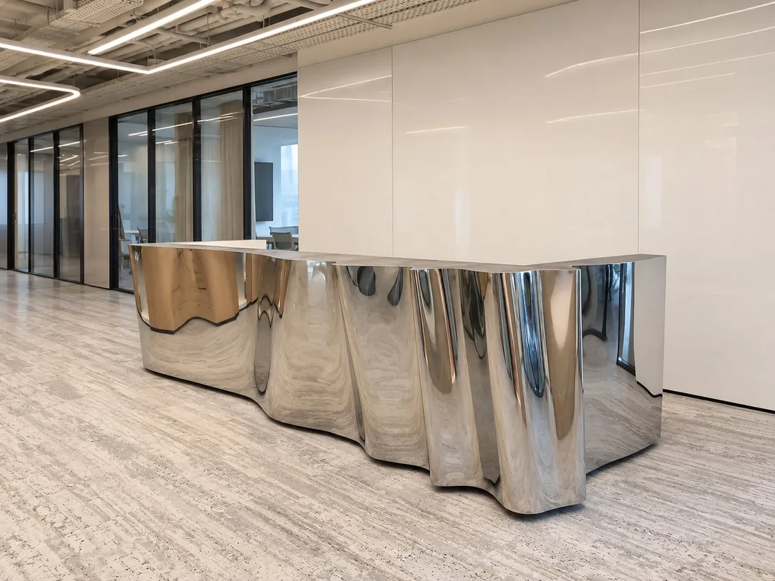 Mirror-polished stainless steel reception desk with a wave front