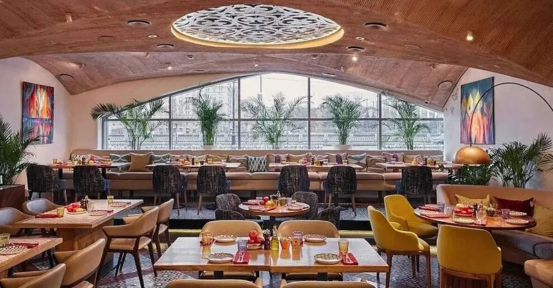Row of tables and armchairs under arched windows