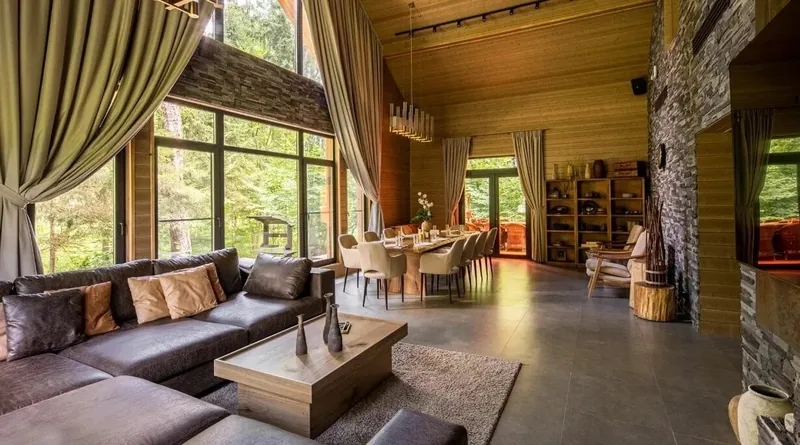 Bath house lounge with a corner sofa under tall windows