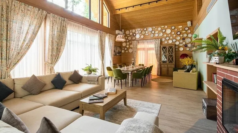 Cream corner sofa with cushions by a fireplace