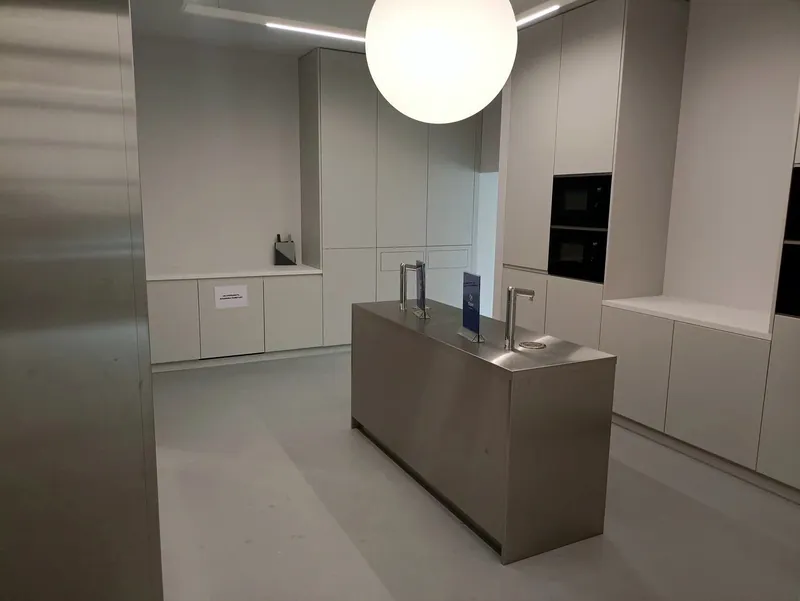 Stainless kitchen island between built-in cabinets