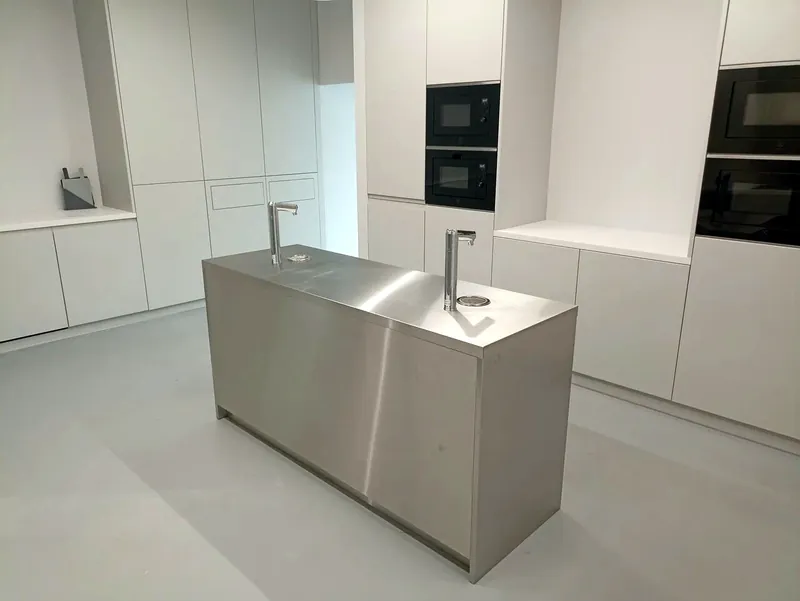 Brushed stainless kitchen island with a sink and tap