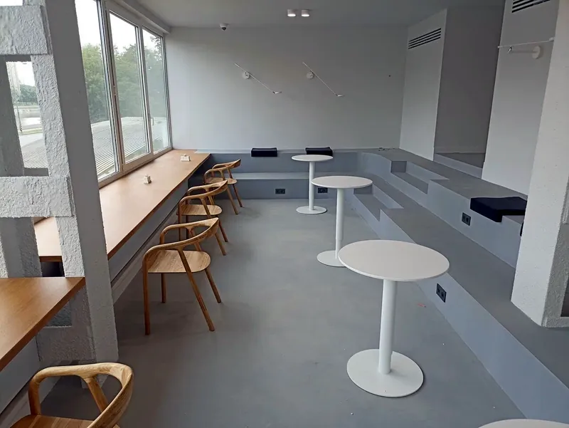 Counter along the windows with round café tables