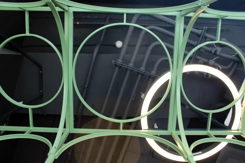 Green steel ceiling grid with circles around a ring light