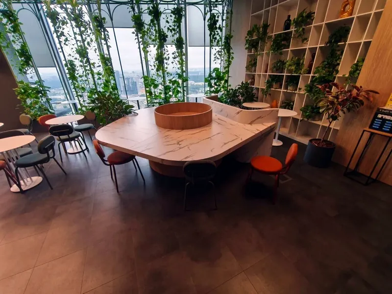 Café zone with a communal table, open shelving and planted window frames