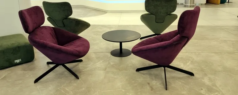 Swivel lounge chairs in burgundy and green around a low table
